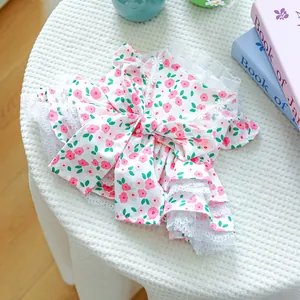 Detail of floral dog dress with lace trim and large bow decoration for small pets