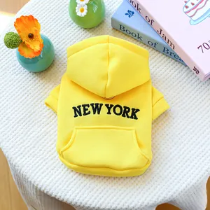 Detail of yellow pet hoodie with New York print and metal D-ring for leash attachment