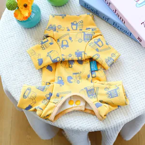 Detail of yellow dog sweatshirt with blue cartoon truck prints and decorative buttons