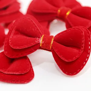 Charming red velvet bow hair clips for dogs and cats featuring white stitching and gold trim