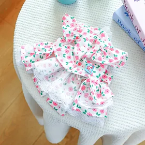 Detailed close-up of floral pet dress featuring white lace hem and pink flower patterns