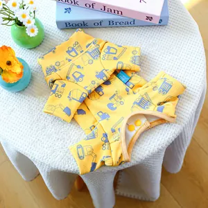 Detail of yellow dog pajamas with blue construction truck print and snap button closure