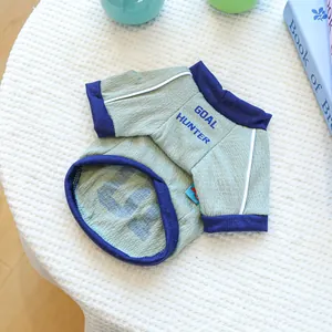 Dettaglio del gilet verde per cani con stampa Goal Hunter e bordi blu