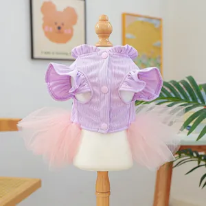 Détail d'une robe pour chien en tricot lilas avec boutons roses et jupe en tulle