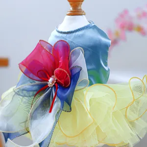 Détail de robe satinée bleue pour chien avec jupe en tulle coloré et nœud en perles