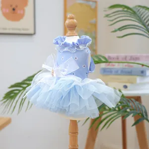 Détail de robe bleu clair pour chien avec imprimé marguerite, dentelle et perle