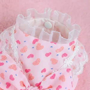 Pink heart print dog dress with white lace collar and snap button detail