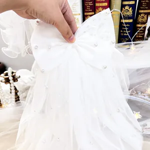 Detailed view of elegant white tulle pet wedding veil with delicate pearls and bow