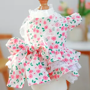 Detail of pink floral dog dress with lace collar and elegant bow on a wooden mannequin