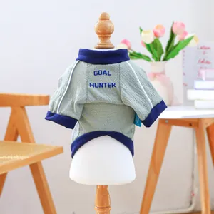 Dettaglio della maglietta verde per cani con stampa Goal Hunter e bordi blu