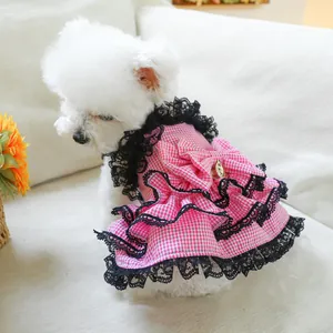 Close-up of pink plaid pet dress with black lace trim and a large bow on the back