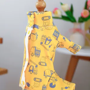 Close-up of yellow dog jumpsuit with cartoon truck prints and snap button closure