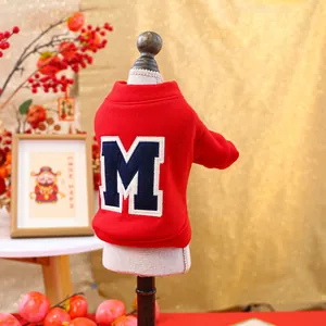 Detail of red festive pet hoodie featuring embroidered M patch on a soft cotton fabric