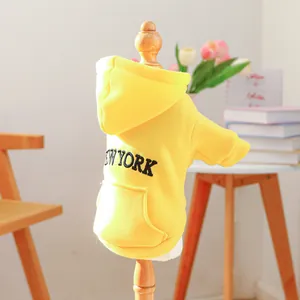 Yellow pet hoodie with New York embroidery and front pocket on a wooden stand