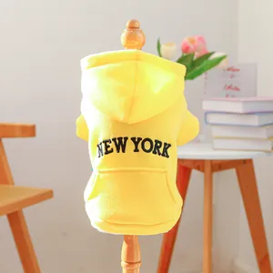 Detail of yellow dog hoodie with New York lettering and front pocket for small pets