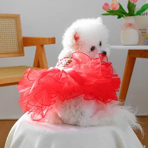 Detail of red tiered tulle pet dress with heart embroidery and bow on a small white dog