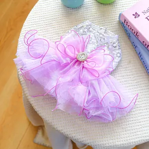 Detail of purple dog dress featuring sequined bodice and large mesh bow with jewel