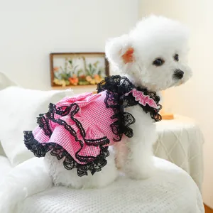 Close-up of pink gingham pet dress with black lace ruffles and floral petal details