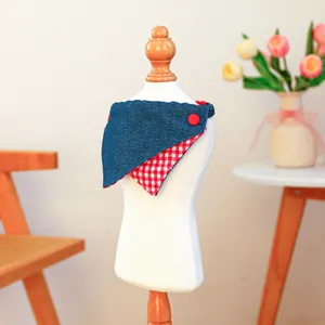 Detail of reversible pet bandana with blue denim side and red gingham check pattern