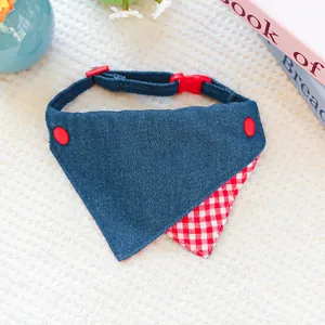 Detail of dark blue denim pet bandana with red checkered trim and buckle closure