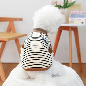 Detail view of a vintage striped pet vest on a white dog in a warm home setting