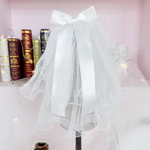 Elegant white tulle wedding veil for small dogs with bow and pearl details on a stand
