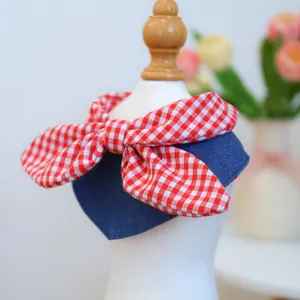 Close-up of pet bandana with red checkered bow and denim fabric on a white mannequin