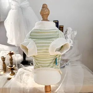Detail view of a green and white striped pet vest with ribbed trim on a wooden mannequin