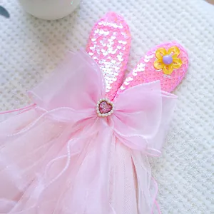 Detail of pink sequined bunny ears headband with mesh bow and pearl heart gemstone