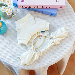 Détail d'un pyjama pour animaux en maille côtelée crème avec broderie jaune et poignets