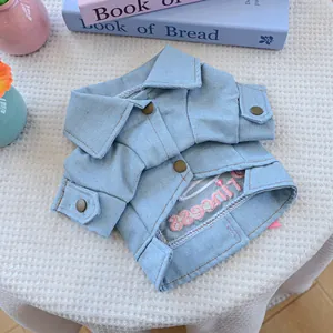 Detail of light blue denim dog jacket featuring metal buttons and pink princess embroidery