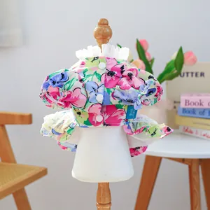 Detailed view of floral pet dress featuring lace ruffles and white buttons on a mannequin