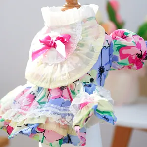 Detail of floral pet dress featuring lace ruffles, pink bow, and multilayered skirt