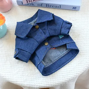 Nahaufnahme der Hundejeansjacke mit Kupferknöpfen und feinen Nähten auf weißem Teppich