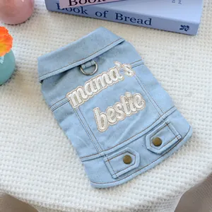 Detail of light blue denim dog vest featuring mama's bestie embroidery and metal D-ring