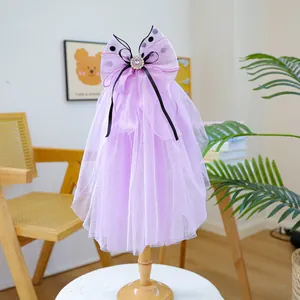 Detail of purple pet wedding veil with mesh bow, faux gemstone, and black ribbon accent
