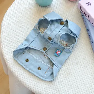 Flat lay of light blue denim pet vest with vintage metal buttons and collar detail