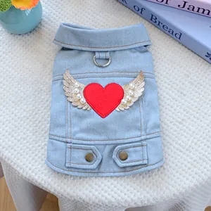 Detail of blue denim pet vest with red heart embroidery and sequined wings decoration