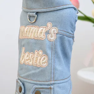 Detail of light blue denim dog vest with mama's bestie embroidery and metal D-ring