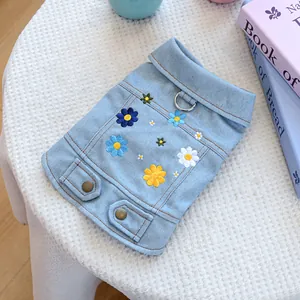 Detailed view of floral embroidery and metal D-ring on the light blue pet denim vest