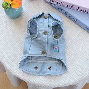 Detail of light blue denim pet vest with daisy floral embroidery and bronze snaps