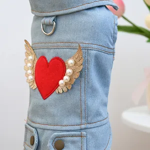 Macro detail of dog denim vest with red heart, gold wings and pearl decorations