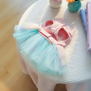 Détail de la jupe en tulle multicouche et des boutons-pression sur une robe rose