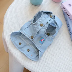 Detailed view of light blue denim dog vest with metal buttons and floral embroidery