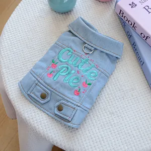 Detail of dog denim vest featuring Cutie Pie embroidery and metal D-ring for leash attachment