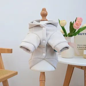 Detail view of beige fleece dog hoodie with white snap buttons on wood model
