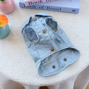 Detail of light blue dog denim vest featuring snap buttons and a red airplane patch