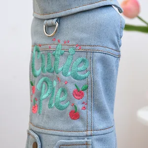 Close-up of light blue pet denim vest with Cutie Pie embroidery and metal D-ring detail
