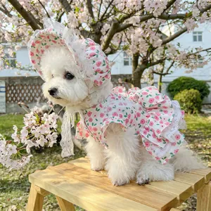Floral pet dress and matching lace hat for small dogs shown in an outdoor cherry setting