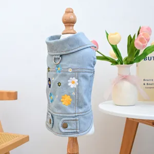 Detailed embroidery of colorful daisies on a light blue denim dog vest with D-ring
